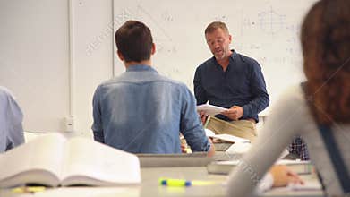 Student raising hand in classroom at the high school