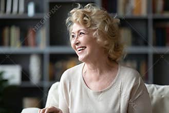 Happy 60s elderly woman looking at distance.