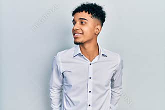 Young african american man wearing business shirt looking to side, relax profile pose with natural face and confident smile
