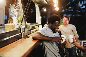 Multiracial people cheering with drinks in counter at food truck restaurant outdoor - Focus on african american man face