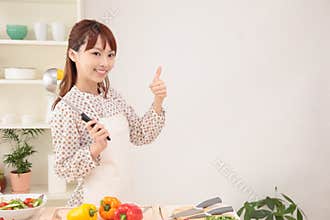 Woman cooking in kitchen with space for copy