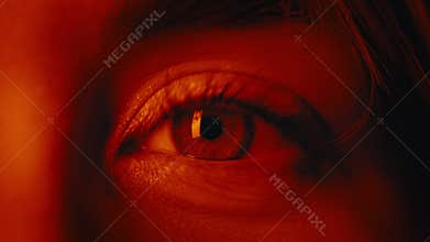 Close up of stunning female blue eyes with red light