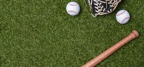 Baseball bat, glove and ball on green grass field.  Sport theme background with copy space for text and advertisment