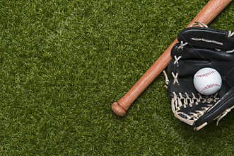 Baseball bat, glove and ball on green grass field.  Sport theme background with copy space for text and advertisment
