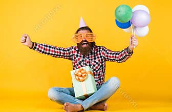 this is my day. man with gift box celebrating birthday. mature hipster with bright colorful balloons. Crazy funny guy