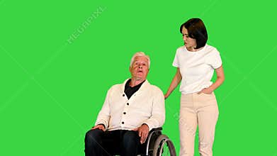 Senior man in a wheelchair talking with a young woman on a Green Screen, Chroma Key.