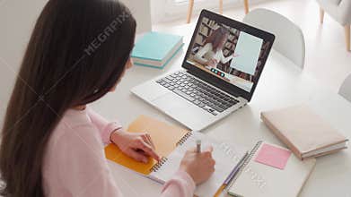 Latin schoolgirl having video class with tutor using pc computer at home.
