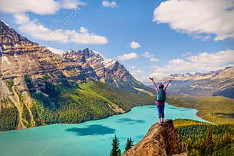 Hiker on the pinnacle of Bow Summit with stunning view of Peyto Lake famous for its bright turquoise colored waters in the summer