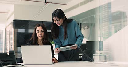 Two women collaborating on joint project in modern coworking office