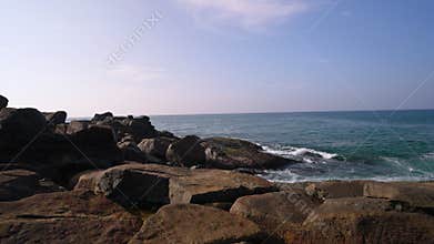 Coastal landscape with serene ocean waves washing over weathered rocks. Seaside scenery for relaxation, ambiance