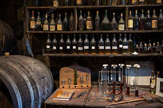Blending process of cognac spirit and old French oak barrels in cellar in old distillery in Cognac white wine region, Charente,