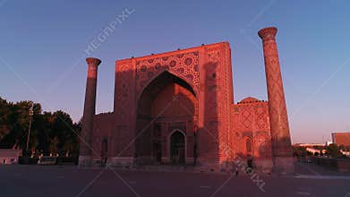 A drone flies near a complex Bibi-Khanym Mosque in Samarkand, Uzbekistan. The building is illuminated by the pink dawn