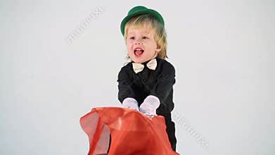 Little boy in magician suit with wand and red