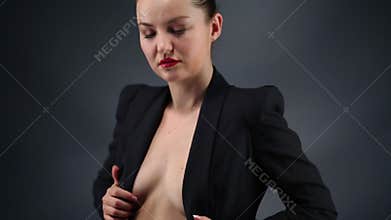 Pretty woman touches her breasts in black jacket