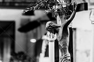 Detail of an ancient wooden crucifix on which an olive branch has been placed as a sign of peace