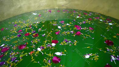 a green water tank is filled with beautiful flowers