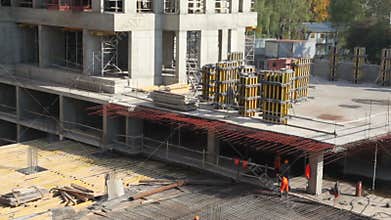 Few workers constructing metal frame on building