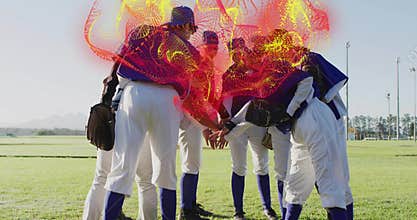 Huddling seven women baseball players stacking hands on grassy field in blue jerseys and gloves