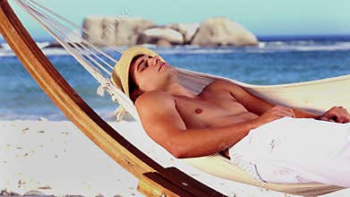 Handsome man relaxing in a hammock