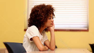 Bored student looking at the camera in classroom