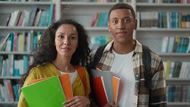Astonished African American man Hispanic woman shocked students classmates looking at camera university library open