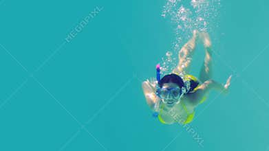 Pretty brunette diving into swimming pool wearing snorkel