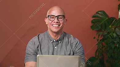 Smiling Bald Man with Glasses Looking at Camera During Video Call or Online Business Meeting
