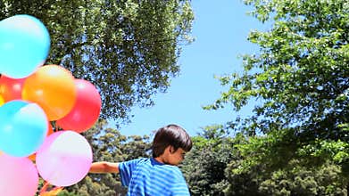 Boy playing with rubber balloon in a park