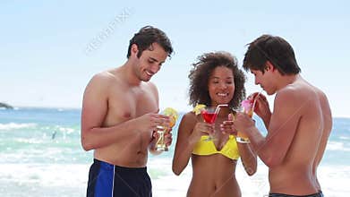 Three friends celebrating and drinking cocktails
