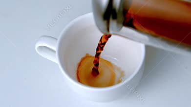 Coffee pouring from cafetiere into white cup