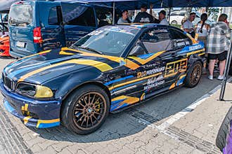 BMW race car at Kyiv Car Drifting Festival, displayed on a tarmac surface Striking design in bold blue and yellow colors, sleek