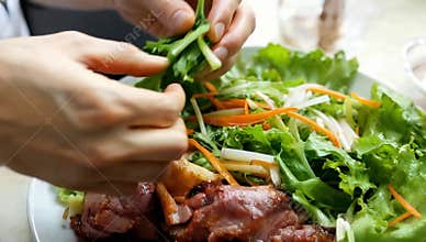 Preparing fresh vietnamese salad with grilled duck meat and vegetables on a white plate