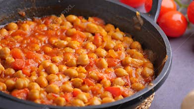 Cooking chickpeas in savory tomato sauce with garlic