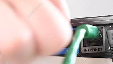 Woman pulling cable out of router.