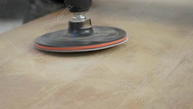 Sander is being used to refine a piece of wood