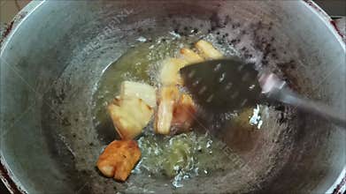 Fry fresh cassava pieces in a pan