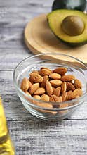 Healthy snacks with almonds and avocado on a wooden table
