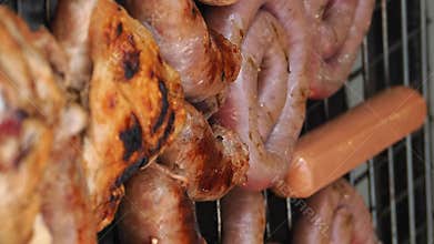 Traditional Italian sausages and chicken breasts prepared on grill at street