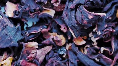 Close-up of dried hibiscus flowers for karkade tea rotating in circle. Natural