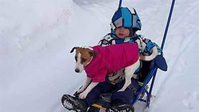 A woman carries her son and dog on a sled.