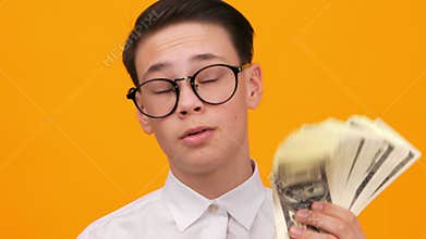 Young Boy Holding Cash in a Bright Setting Showing Excitement About Money While Engaging the Viewer in 4k Footage