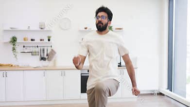 Man practicing indoor fitness exercises in home kitchen environment