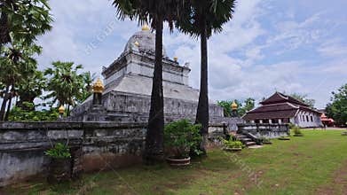 Ancient stupa and palm trees in wat visounnarath, luang prabang, laos