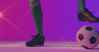 Soccer athlete nudging ball forward then hopping onto it and showing balance on gradient backdrop