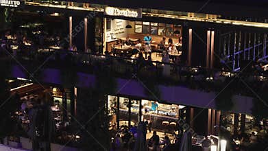 View of Istanbul in evening. View of passenger port, pedestrian embankment, cafes and restaurants, Turkey. People