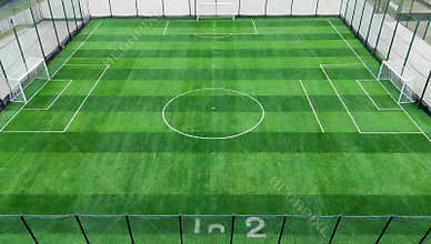Aerial view of a vibrant green soccer field with white lines and goals ready for a match day