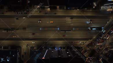 Aerial top down view of a bustling highway in Lima, Peru at night. Cars with headlights on travel along the illuminated