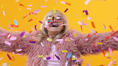 Happy retired female throwing up colorful confetti slow motion, having fun party