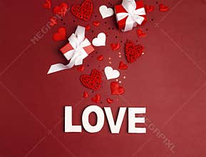 St. Valentines Day background word love, gifts and decorative hearts on red.
