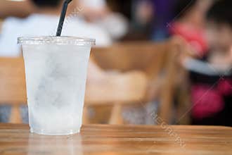 Drinking ice water with ice cube in plastic glass